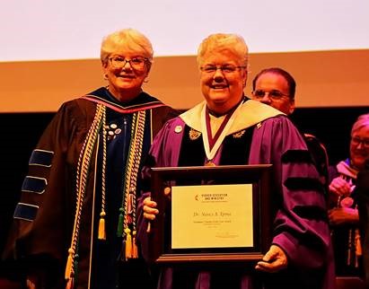 Dr. Christine Bahr, provost, congratulates Dr. Nancy Ypma,  2019 UMC Exemplary Teacher Award winner