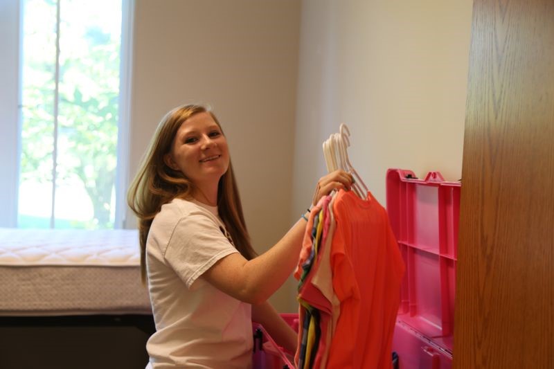 Female Student Putting Clothes in Closet