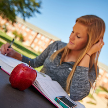 Female Student Studying Outside with Textbook