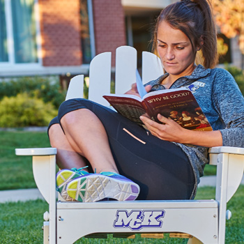 Female Student Reading a Book Outside