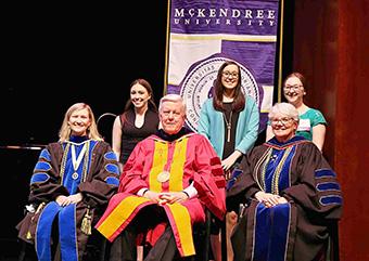 Division of Science and Mathematics honorees Kristyn Tully ’19 (mathematics), Ashley Hathaway ’19 (biology) and Brittni Futrell ’19 (biopsychology) are joined on the stage by (seated) Dr. Michele Schutzenhofer ’03, division chair; President James Dennis; and Dr. Christine Bahr, provost and dean.