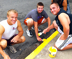 Students painting street curb